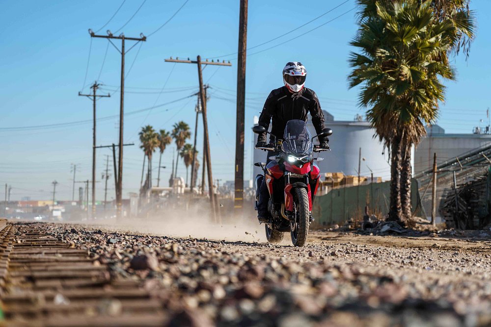 Triumph Tiger 850 Sport riding next to railroad tracks