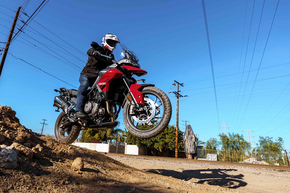 Triumph Tiger 850 Sport jumping off a small dirt mound