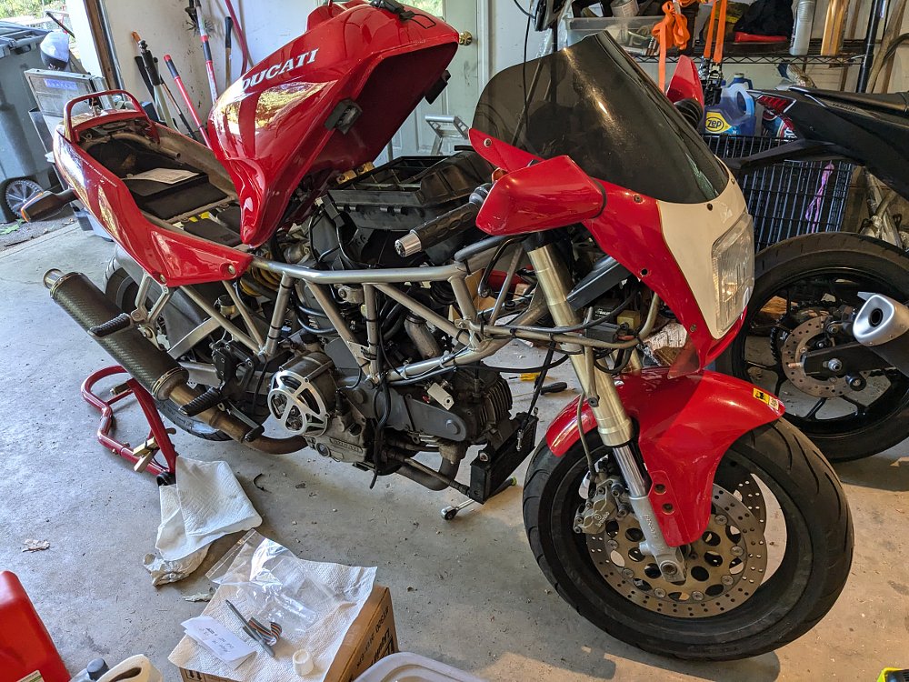 Ducati in the workshop with the tank propped up to access the engine