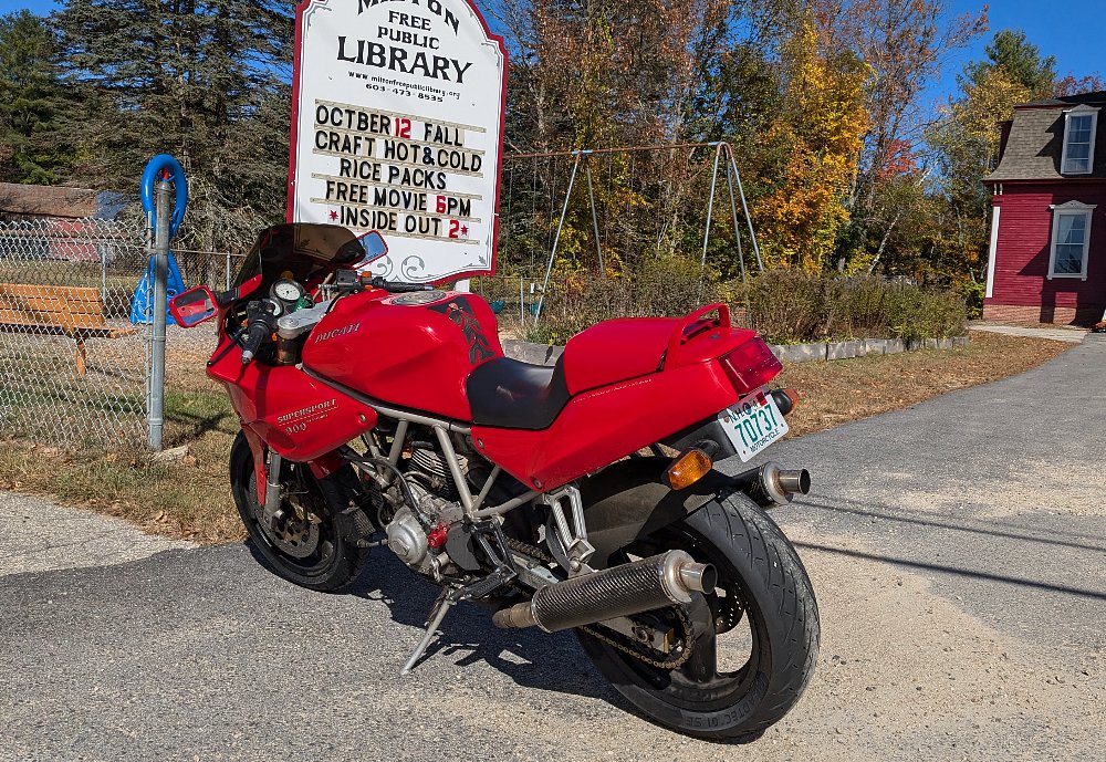 rear view of the Ducati parked in front of a library sign